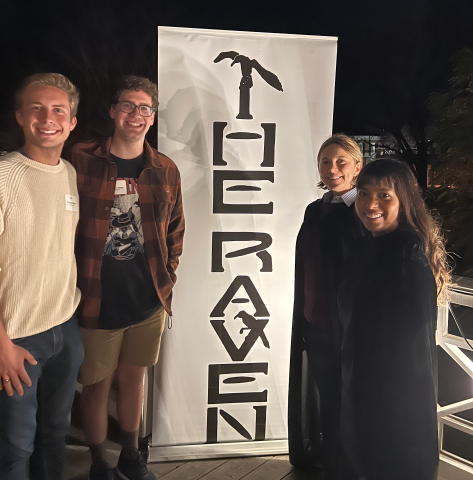 Two male students on left, vertical banner with The Raven, then two female students on right