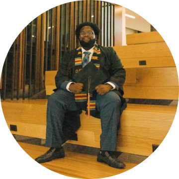 MSDS student Didier Kasole poses for a picture in his graduation cap and gown.