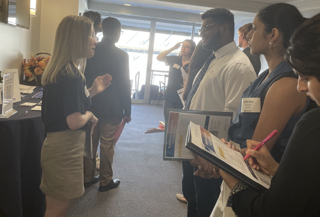 Several students are listening to a recruiter speak.