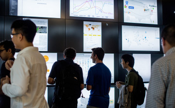 Data Science students looking at research wall