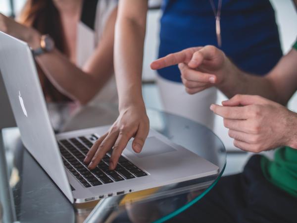 hands pointing to a computer screen