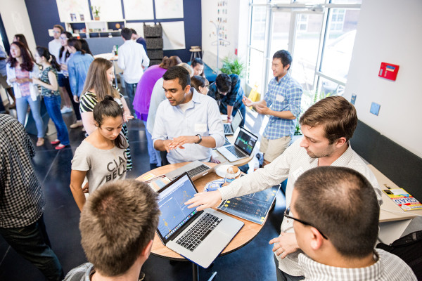 Research presentation day with many students and laptops