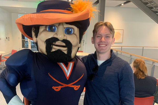 UVA Data Science MSDS Alumni Levi Davis posing with CavMan Cavalier mascot