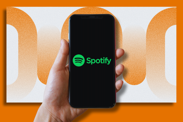 Graphic of a person's hand holding an iPhone with the Spotify logo on a display screen. The background features an abstract orange design.