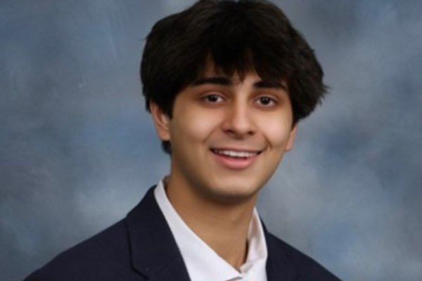 Headshot of Zach Hasan smiling wearing a suit and red tie.