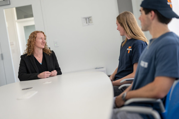 UVA Data Science career counselor chats with two students in a white room with white table