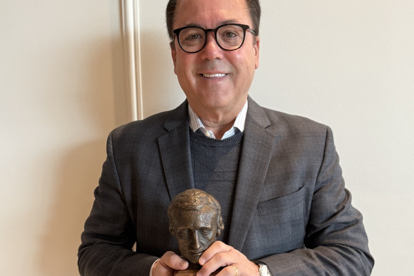 Phot of Scott Stephenson receiving the 2025 Alumni Raven Award.