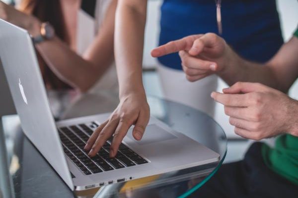 hands pointing to a computer screen