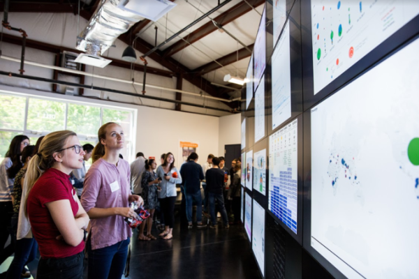 Two students looking at the data wall screen