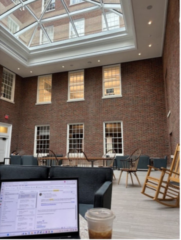 Student view while studying at UVA Shannon Library with crystal ceiling and laptop with coffee beside it